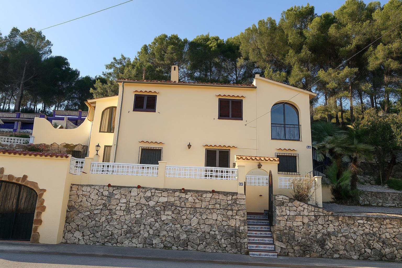 Casa Espyra von vorne mit mediterraner Fassade und Pinien im Hintergrund