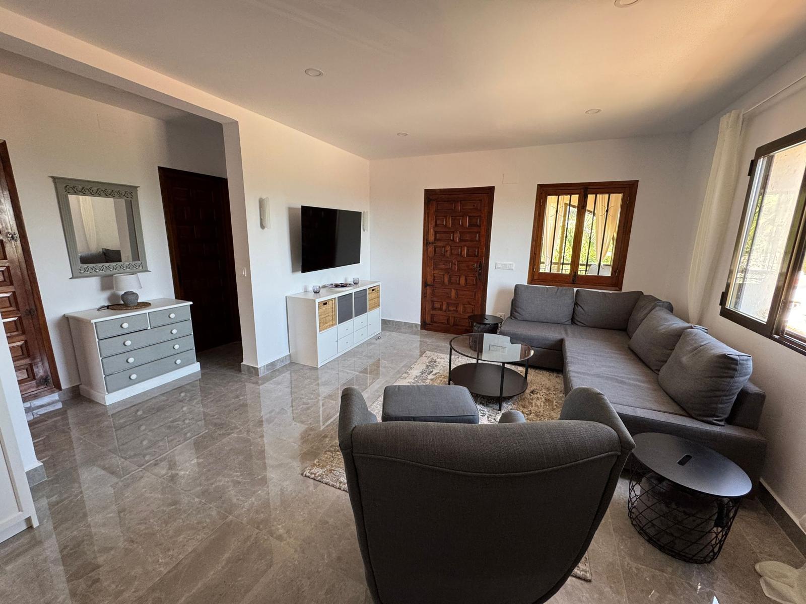 Helles Wohnzimmer mit Sofa und TV