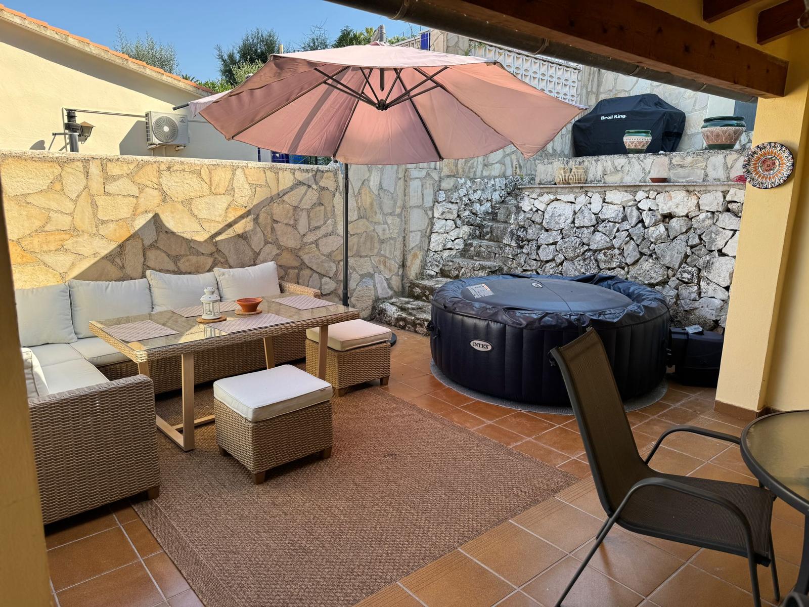 Überdachte Terrasse mit Lounge, Sonnenschirm und Whirlpool